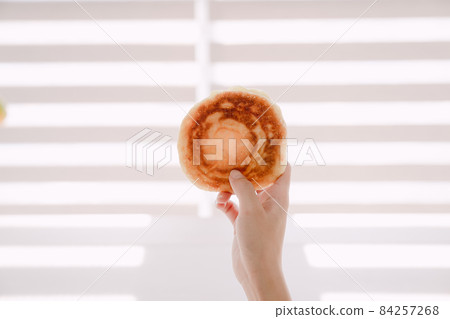 一隻手拿著韓國冬季小吃 hotteok 一隻手拿著韓國冬季小吃 hotteok 84257268