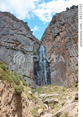 high waterfall, cliff and rocks, bottom view of a mountain waterfall, nature, landscape in the mountains 84257593