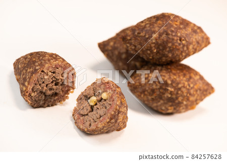 Traditional kebbe and pita bread on big round plate in lebanese restaurant Traditional kebbe and pita bread on big round plate in lebanese restaurant 84257628
