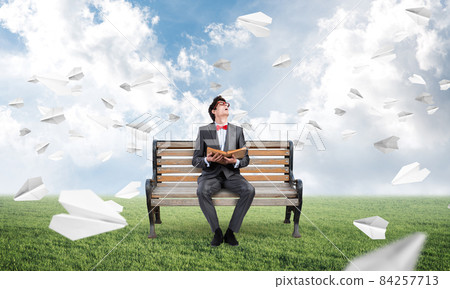 young student with a book on a bench young student with a book on a bench 84257713