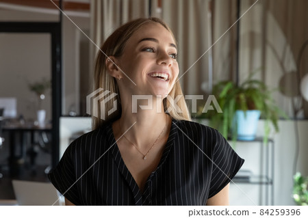 Joyful female employee laughing looking in distance. Joyful female employee laughing looking in distance. 84259396