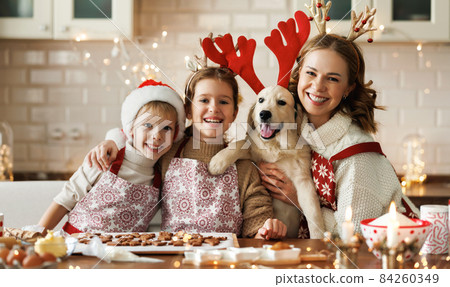 Happy family mother, two kids with dog golden retriever in kitchen, preparing Christmas cookies Happy family mother, two kids with dog golden retriever in kitchen, preparing Christmas cookies 84260349