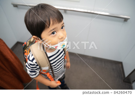 A 4-year-old boy looking at the floor display in the elevator A 4-year-old boy looking at the floor display in the elevator 84260470