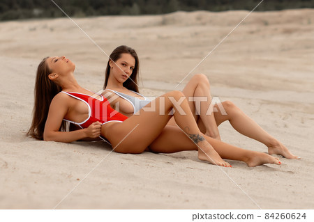 Sexy girlfriends with bare breast on beach 84260624