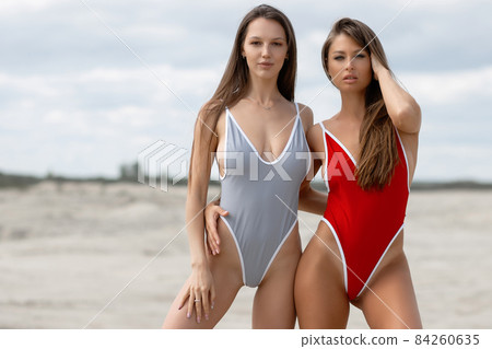 Sexy women in swimsuits on beach 84260635