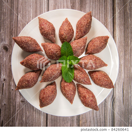 Traditional kebbe and pita bread on big round plate in lebanese restaurant 84260641