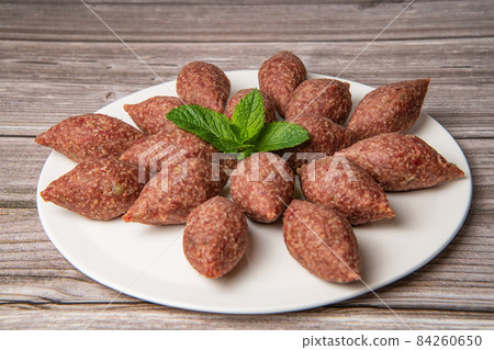 Traditional kebbe and pita bread on big round plate in lebanese restaurant 84260650