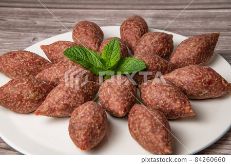 Traditional kebbe and pita bread on big round plate in lebanese restaurant Traditional kebbe and pita bread on big round plate in lebanese restaurant 84260660