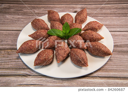 Traditional kebbe and pita bread on big round plate in lebanese restaurant Traditional kebbe and pita bread on big round plate in lebanese restaurant 84260687