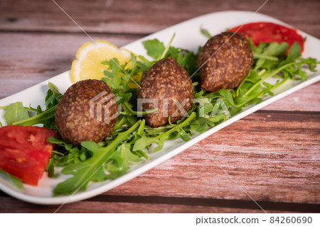 Traditional kebbe and pita bread on big round plate in lebanese restaurant 84260690