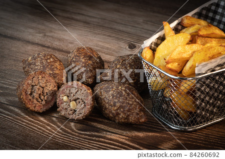 Traditional kebbe and pita bread on big round plate in lebanese restaurant Traditional kebbe and pita bread on big round plate in lebanese restaurant 84260692