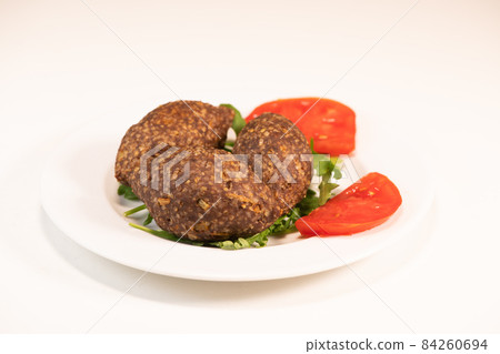 Traditional kebbe and pita bread on big round plate in lebanese restaurant Traditional kebbe and pita bread on big round plate in lebanese restaurant 84260694