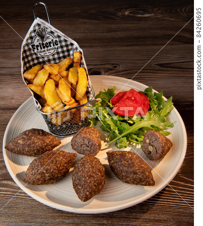 Traditional kebbe and pita bread on big round plate in lebanese restaurant 84260695