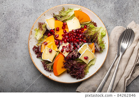 Healthy vegetarian persimmon salad with brie top view 84262846