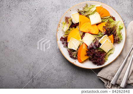 Healthy vegetarian persimmon salad with brie copy space 84262848