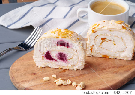 Biscuit roulade with cherry on wooden board 84263707