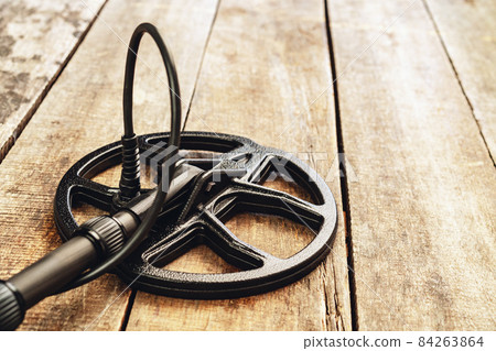 Metal detector tool on wooden board close up 84263864