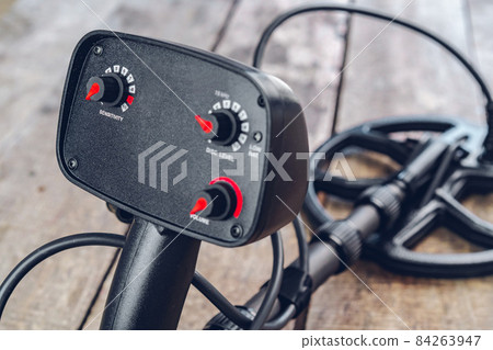 Metal detector tool on wooden board close up 84263947
