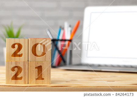 Wooden cubes 2021 Year on working table with open laptop 84264173