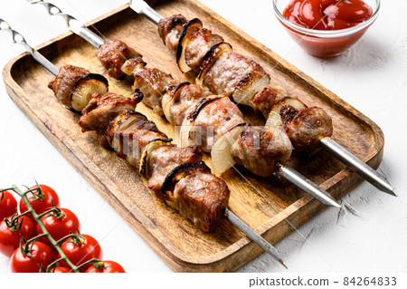 Shish kebab BBQ meat with onions and tomatoes, on white stone table background 84264833