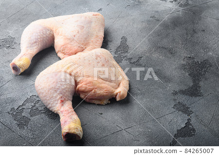 Uncooked Chicken Thigh or legs, drumsticks, on gray stone background, with copy space for text 84265007