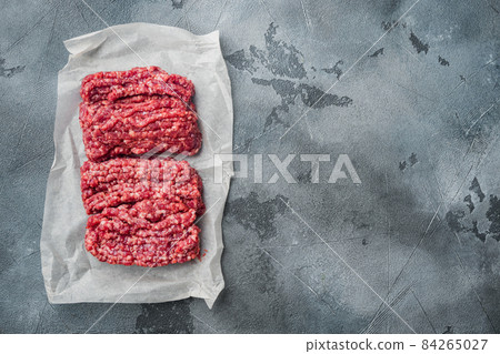 Organic Raw Grass Fed Ground Beef, on gray background, top view flat lay with copy space for text Organic Raw Grass Fed Ground Beef, on gray background, top view flat lay with copy space for text 84265027