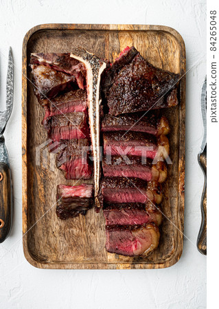 Porterhouse steak is grilled sliced on a piece, on white stone background, top view flat lay Porterhouse steak is grilled sliced on a piece, on white stone background, top view flat lay 84265048