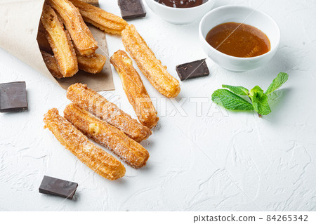 Churros sprinkled with powdered sugar, on white background with space for text, copyspace 84265342