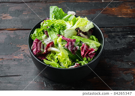 Fresh leaves of different lettuce salad, on old dark wooden table background 84265347