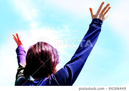 一位年輕女子正張開雙手仰望天空 84266449