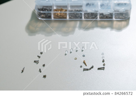 Bolts for repairing eyeglass frames on a white background. 84266572