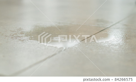 Water drips onto the tiled floor. 84266575