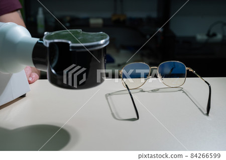 The optician fixes the frames of the glasses. 84266599