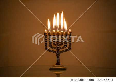 Hanukkah menorah closeup with burning candles for holiday card background. Retro old style hanukkah Hanukkah menorah closeup with burning candles for holiday card background. Retro old style hanukkah 84267303