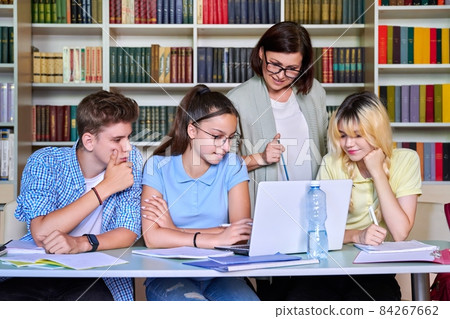 Lesson in library, high school teacher with group of teenagers Lesson in library, high school teacher with group of teenagers 84267662