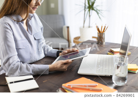 Freelancer young woman using tablet pc 84269901