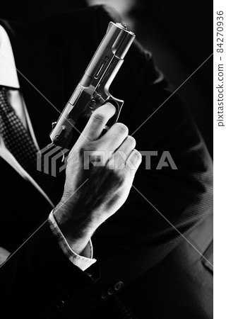 Elegant man holding gun 84270936