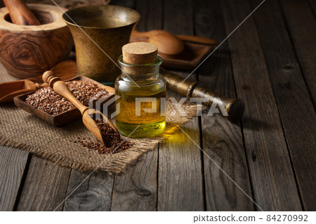 Flaxseeds and linseed oil on an old wooden table. 84270992