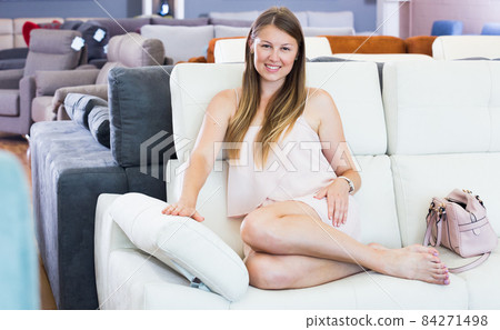 Smiling woman testing new sofa 84271498