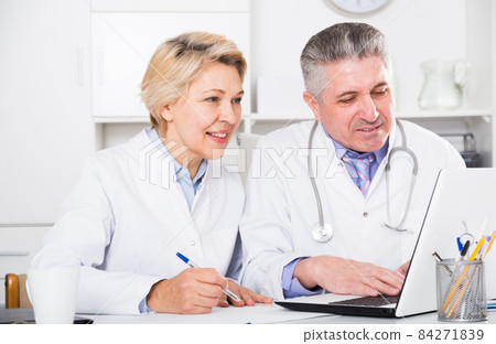Doctor and nurse reading information Doctor and nurse reading information 84271839