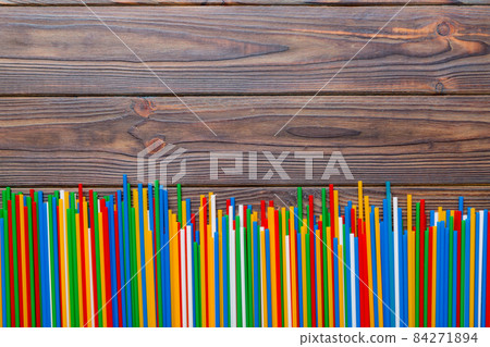 Heap of colorful plastic drinking straws on Colored background, flat lay. Copy Space for text 84271894