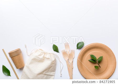 set of empty reusable disposable eco-friendly plates, cups, utensils on light white colored table background. top view. Biodegradable craft dishes. Recycling concept. Close-up 84271905