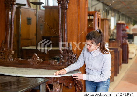 Satisfied woman chooses new furniture for home in the store Satisfied woman chooses new furniture for home in the store 84271984