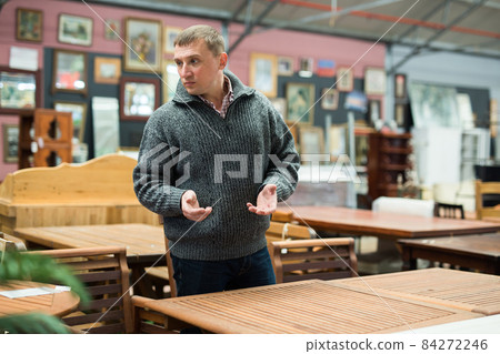 Puzzled man choosing new furniture 84272246