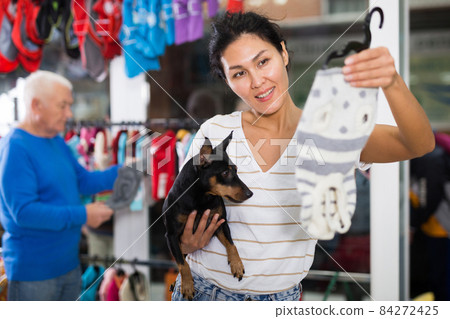 Oriental woman with her dog in pet shop 84272425