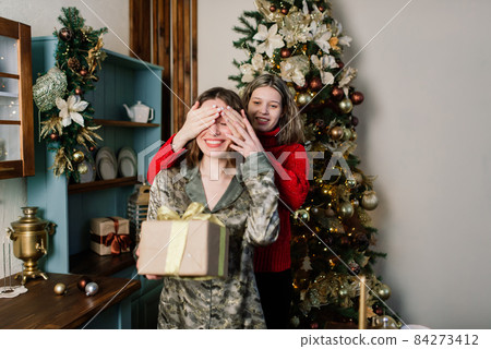 Lesbian couple together indoors cheerfully communicate, preparing for celebration of Christmas. Lesbian couple together indoors cheerfully communicate, preparing for celebration of Christmas. 84273412