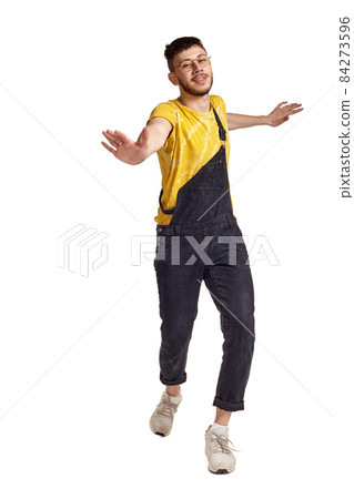 Full-length portrait of a funny guy dancing in studio isolated on white background. Full-length portrait of a funny guy dancing in studio isolated on white background. 84273596