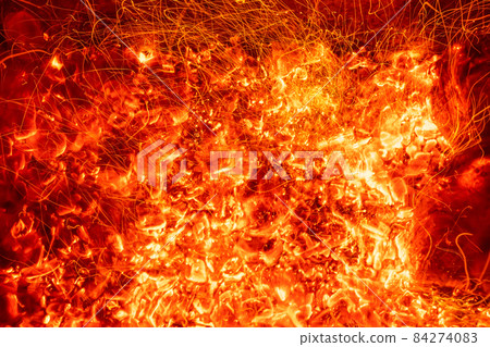 Top above overhead detail view od abstract hot red burning wooden coal background in bbq grill brazier or firepit at dark night time. Beautiful inferno heat sparks glowing flaming at hearth stove 84274083