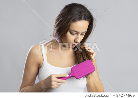 Young woman brushing her long hair Young woman brushing her long hair 84274669
