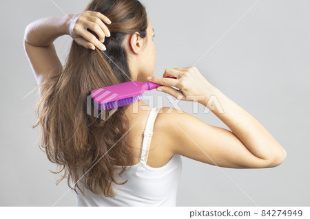 Young woman brushing her long hair Young woman brushing her long hair 84274949